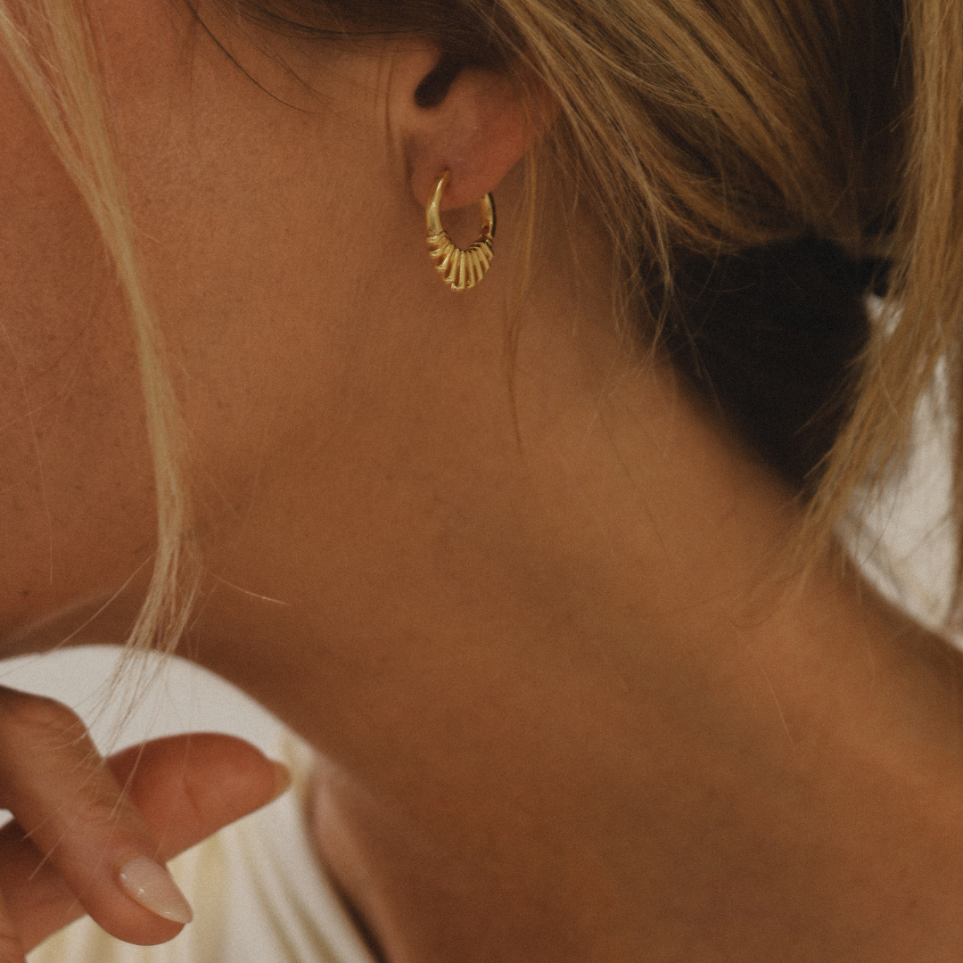 Boucles d'oreilles anneaux or avec rayons sur mannequin